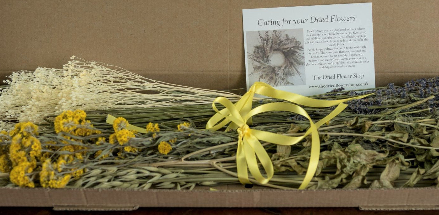 Selection of yellow dried flowers and natural grasses in a letterbox size box