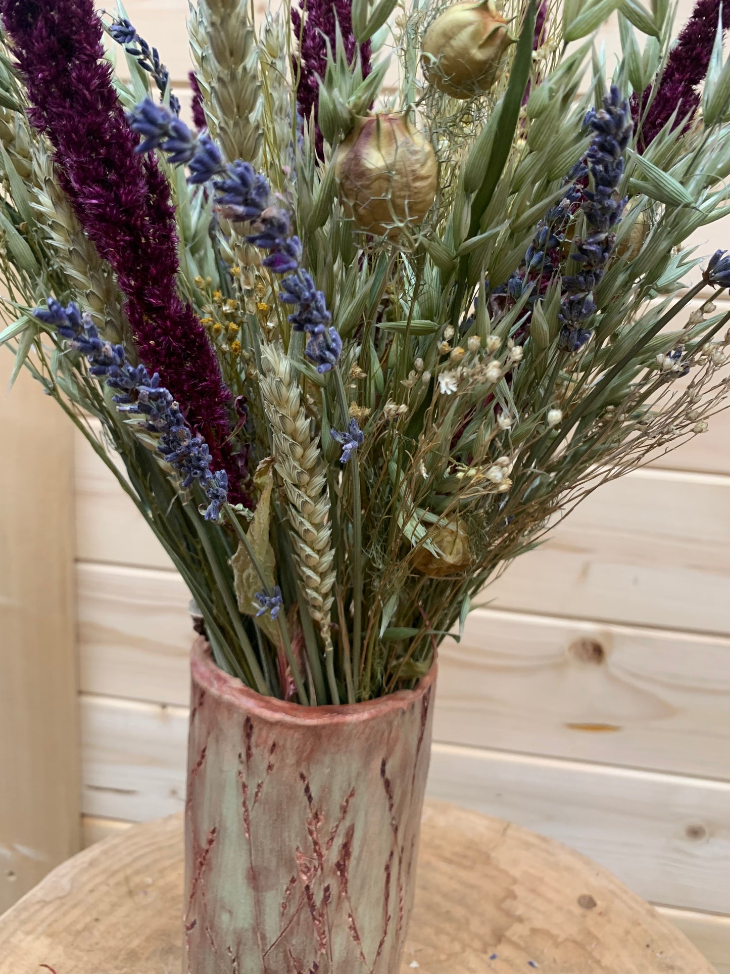 Bouquet of dried flowers in a vase against a wooden background